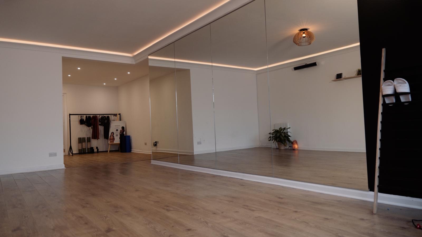 The practice room at Bushido Studio before practice, a wood floor and a mirrored wall